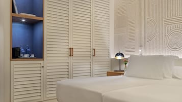A bedroom with a bed, a nightstand, a lamp, and a wardrobe with a mirror.