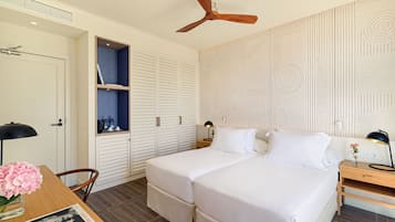Un dormitorio moderno con una cama grande, un armario y un escritorio con una lámpara y un libro.