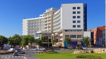A modern hotel with multiple floors, a curved facade, and a casino sign.