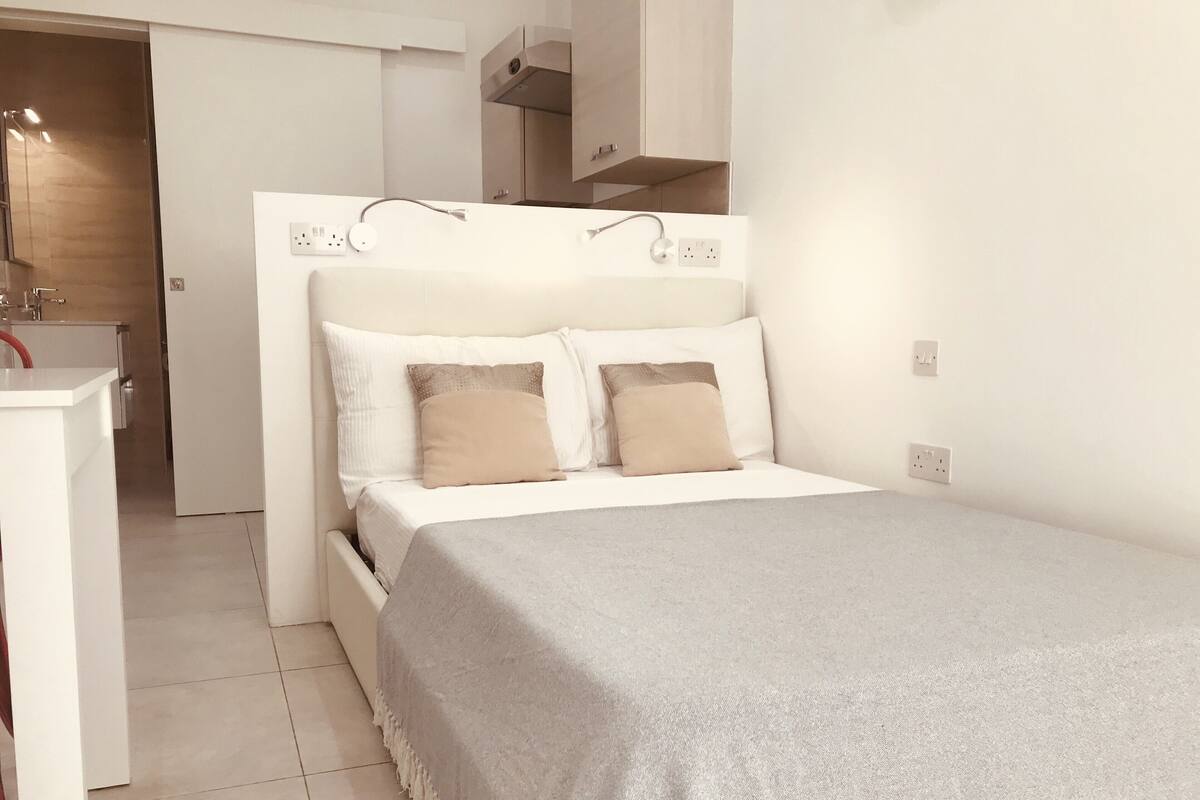 Une chambre à coucher moderne avec un lit, des tables de chevet et une armoire intégrée.