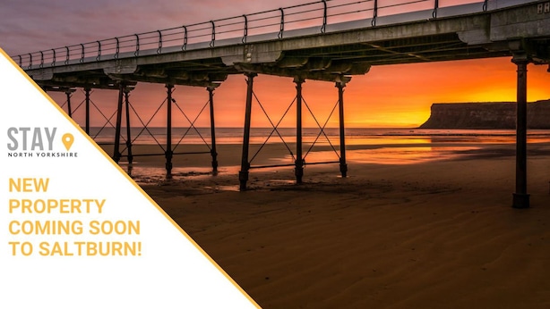 A pier over a beach at sunset with text indicating new property coming soon to Saltburn. - Caedmon Prospect (Whitby)
