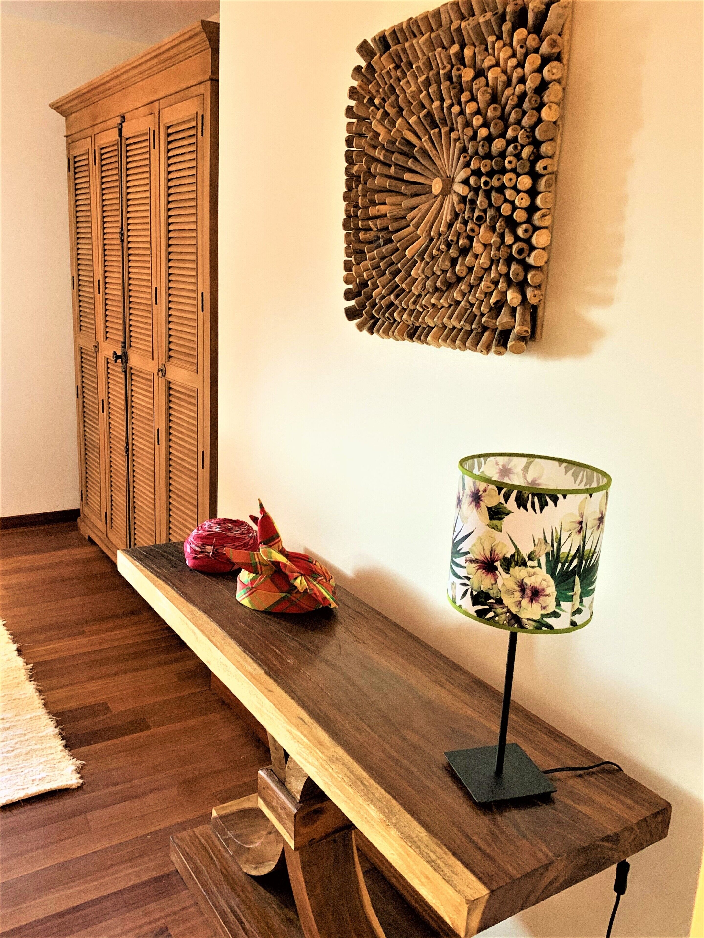 A wooden bench with a lamp and decorative items on a wall.