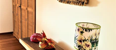 A wooden bench with a lamp and decorative items on a wall.