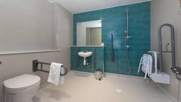 Un baño moderno con inodoro, lavamanos y zona de ducha.