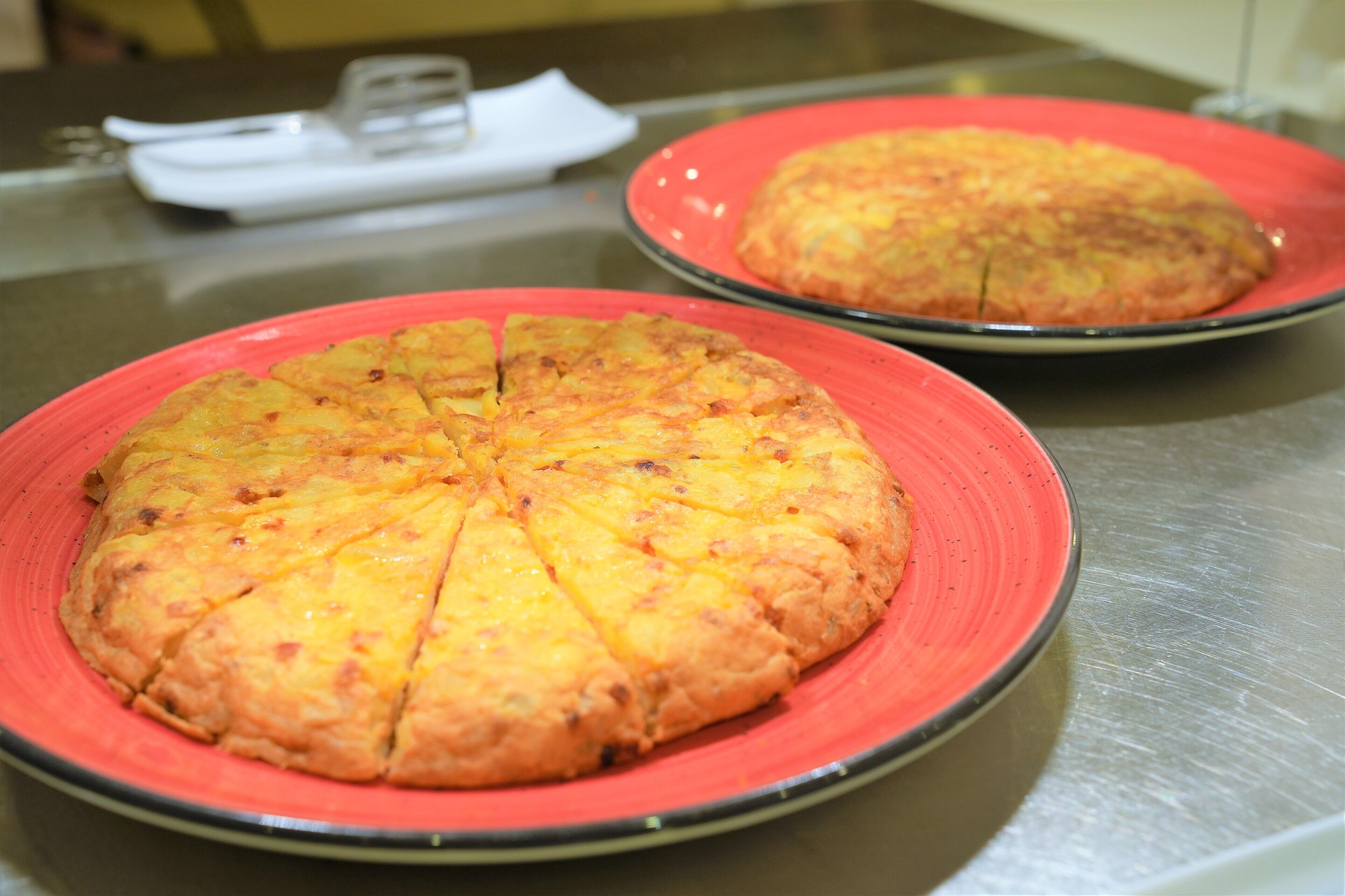 Two round dishes with slices on a metallic surface.