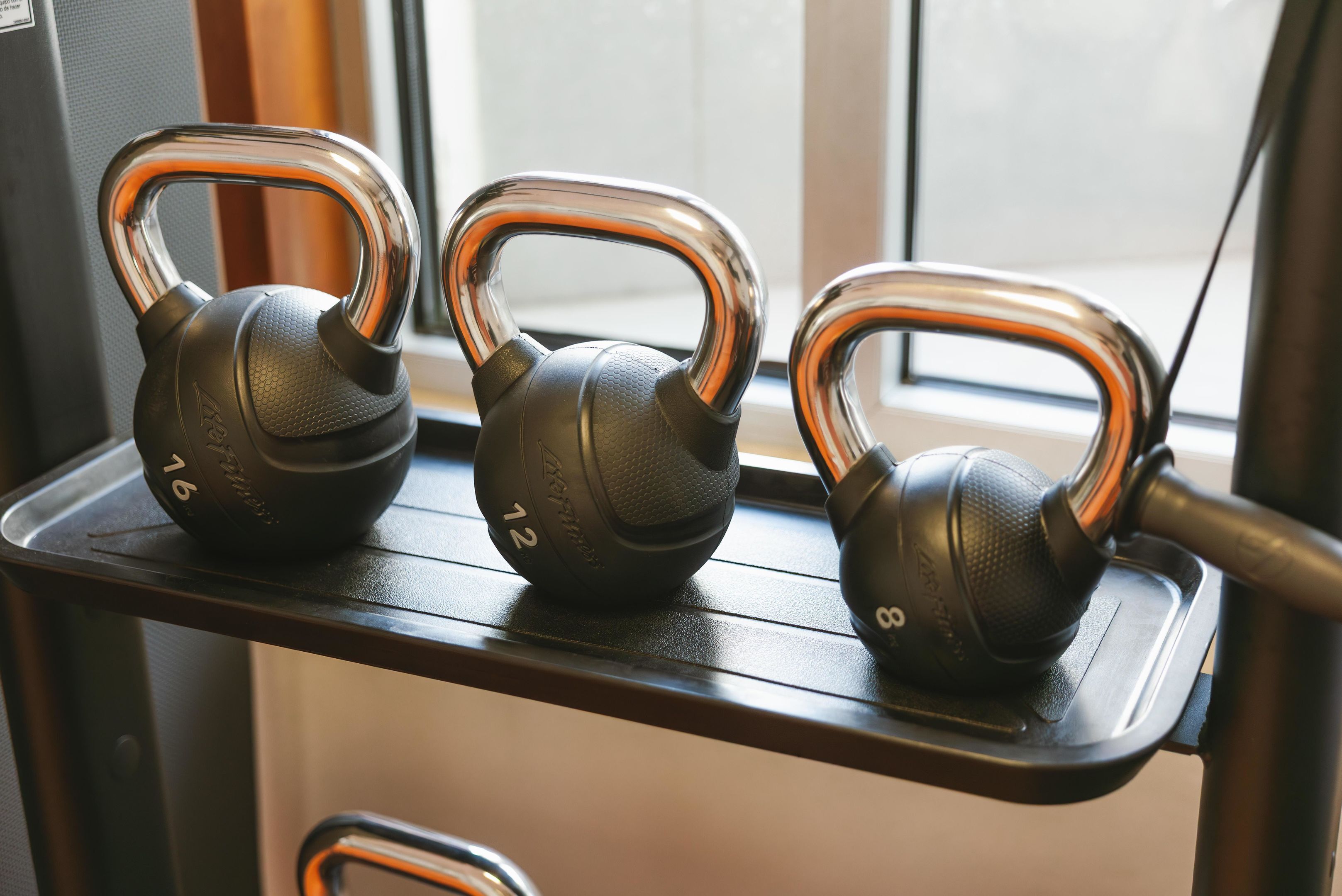 Three kettles on a shelf.