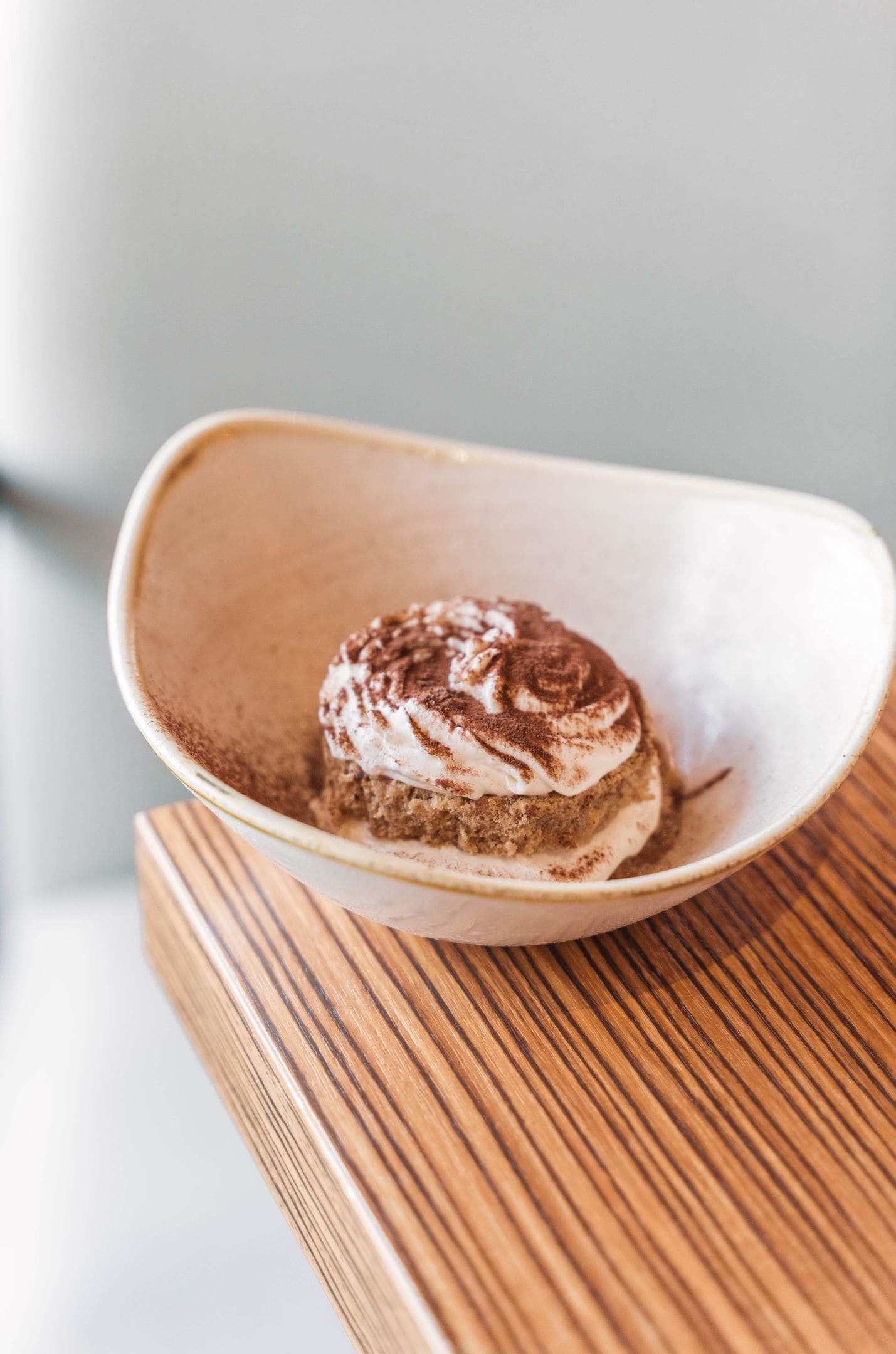 A dessert in a bowl on a wooden table.