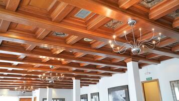 A hotel interior with wooden ceiling beams and chandeliers.