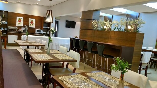 Un espace repas moderne avec des tables et des chaises en bois, ainsi qu’un bar central.