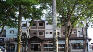 Un hôtel avec une enseigne bien visible, entouré d’arbres et situé à côté d’autres bâtiments.