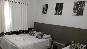 Une chambre avec deux lits, une table de chevet et une fenêtre avec des rideaux.