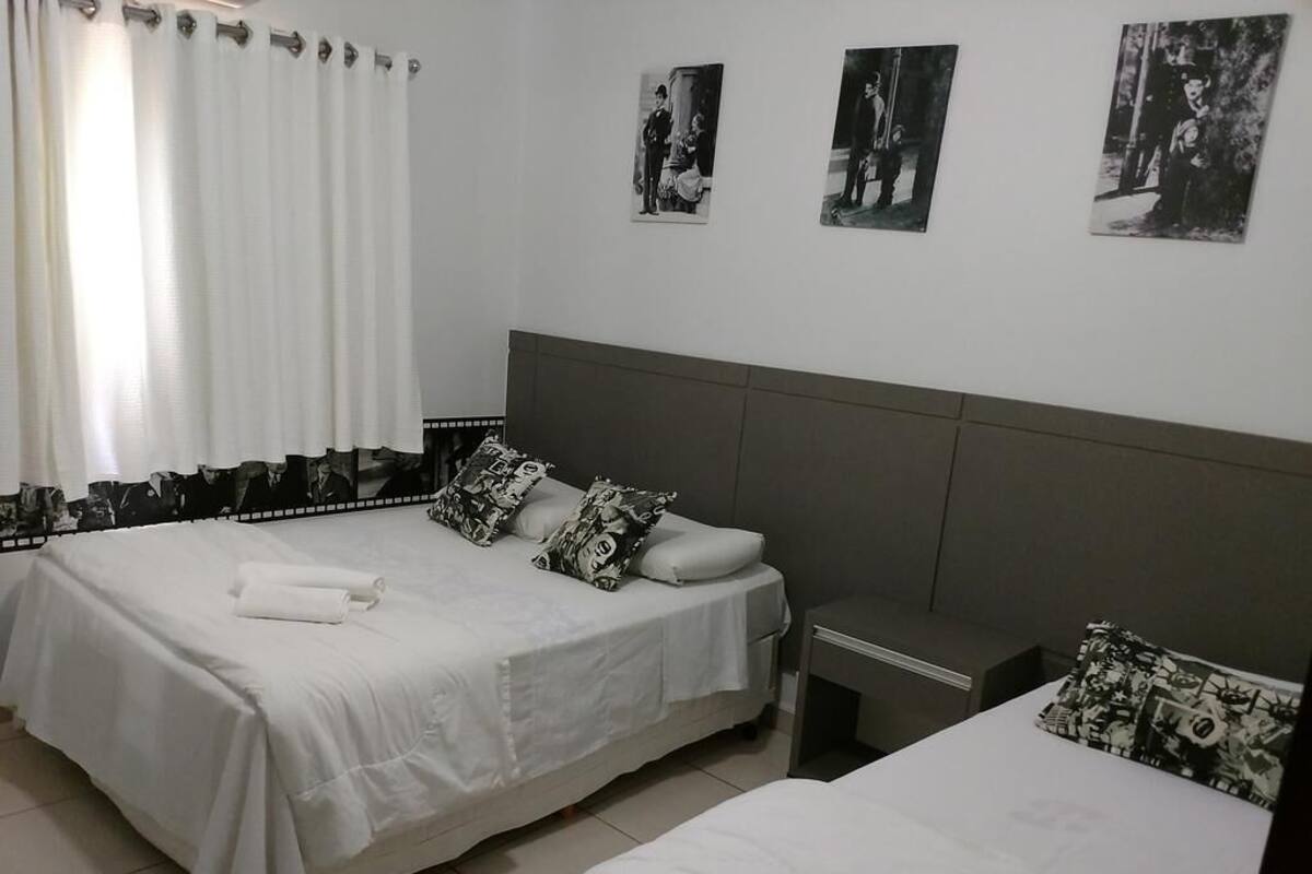 Une chambre avec deux lits, une table de chevet et une fenêtre avec des rideaux.