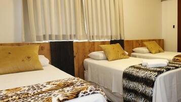 A hotel room with two single beds, each with a wooden headboard, white bedding, and a leopard print blanket.