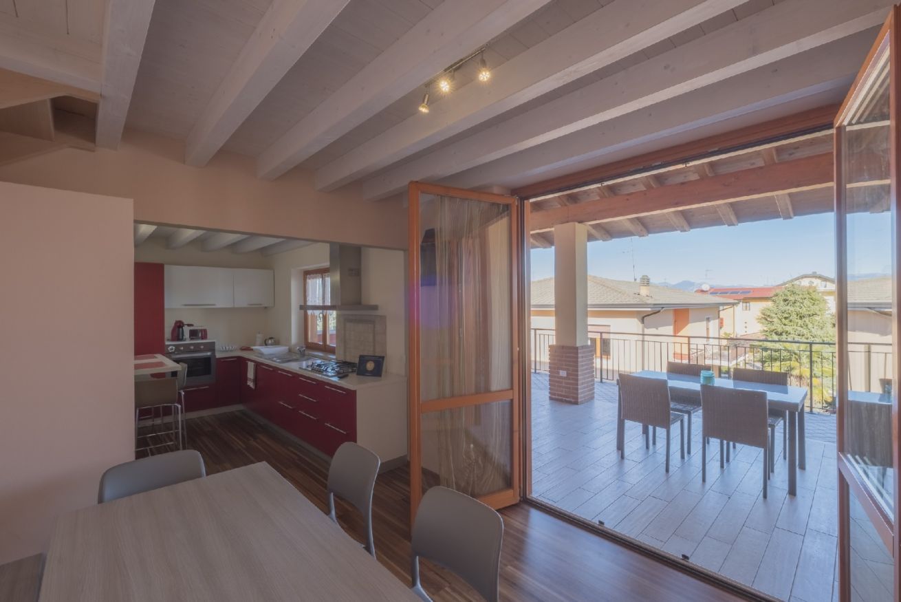 A modern kitchen with red cabinets and a dining area with a table and chairs.