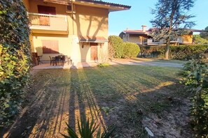 Una propiedad residencial con un edificio de dos pisos, un camino pavimentado y un césped bien cuidado.