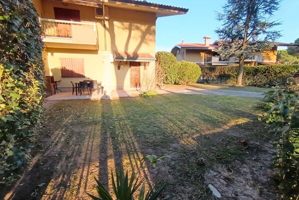 A residential property with a two-story building, a paved driveway, and a well-maintained lawn.