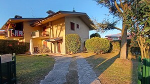 A two-story house with a paved driveway leading to the entrance.