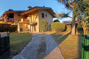 Una casa de dos pisos con un camino pavimentado que conduce a la entrada.