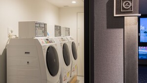 Uma área de lavanderia com várias máquinas de lavar e um painel de controle.