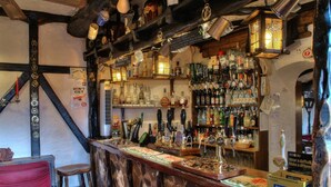 Eine Bar mit einer Auswahl an Spirituosenflaschen, einer Theke mit einer Speisekarte und einem Hocker.