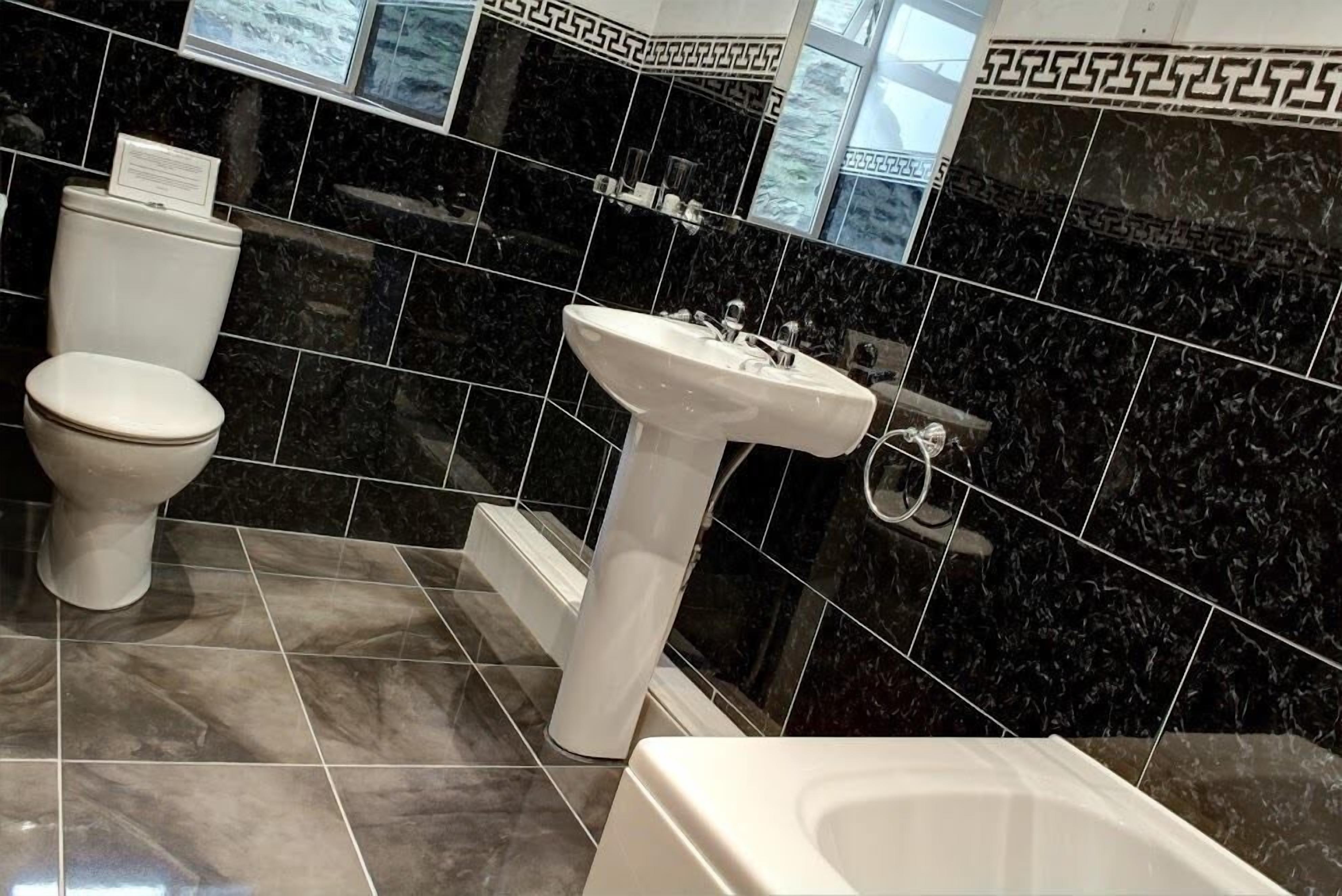 A bathroom with a toilet, sink, and bathtub.
