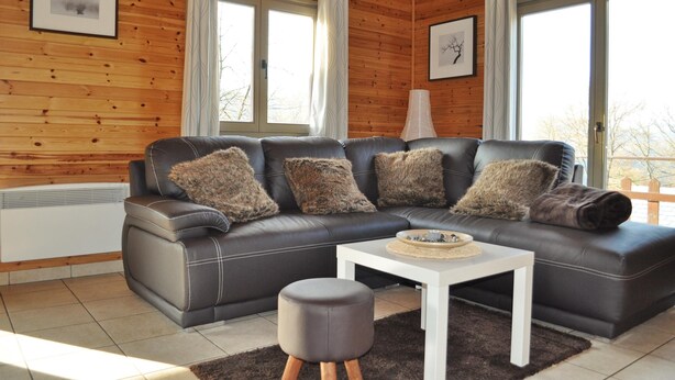 Ein modernes Wohnzimmer mit einem Ledersofa, einem weißen Couchtisch und einem runden Hocker.