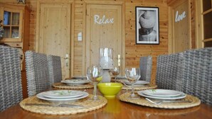 Un interior de madera con una mesa de comedor para cuatro personas, rodeada de sillas de mimbre.