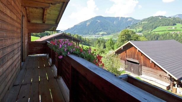 A wooden cabin with a balcony overlooking a mountainous landscape. - Lush Holiday Home in Hüttau near Ski Area (Huettau)