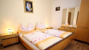 A neatly arranged bedroom with a wooden bed, two bedside tables, a nightstand, a mirror, and a framed picture on the wall. - Cozy Apartment in Sankt Johann im Pongau near Ski Area (Sankt Johann im Pongau)