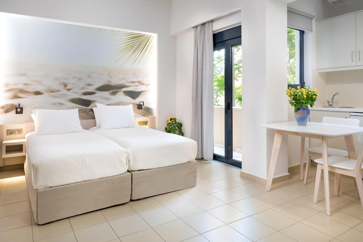 A modern bedroom with a large bed, a small table, and a view of the outdoors.