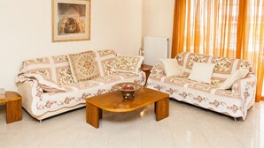 Una sala de estar con dos sofás de estampado floral, una mesa de centro de madera y un cuadro en la pared.