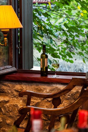 A wooden chair, a bottle of wine, and a glass on a windowsill with a view of greenery. - Picturesque Villa in Parnassos (Delphi)