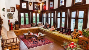 Une pièce chaleureuse avec un banc en bois, un tapis rouge et une table basse en bois.