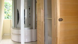 Une pièce avec un sauna, une porte en bois et une fenêtre donnant sur un paysage verdoyant.