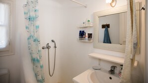 A bathroom with a shower, a sink, a mirror, and a towel rack. - Villa Anemoessa Olive Green with Pool (Mykonos)