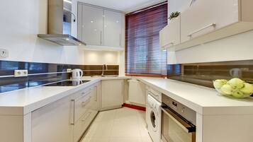 Eenvoudig appartement, 2 slaapkamers | Privékeuken | Een koelkast met diepvriezer, een oven, een kookplaat, een waterkoker