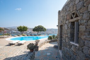 A stone building with a pool and lounge chairs. - Villa Anemoessa Sky Blue with Pool (Mykonos)