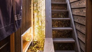 A wooden staircase leading to a room with a bamboo garden. - Nijojo Taiken Inn (Kyoto)