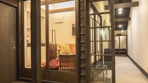 A hallway with a wooden bench, a glass door, and a staircase. - Nijojo Taiken Inn (Kyoto)