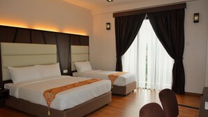 A hotel room with two beds, a desk, and a chair. - HOTEL GRAND BARON TAIPNG (TAIPING)