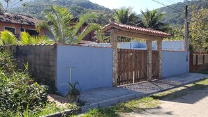 Zona residencial con entrada protegida por un muro de concreto y una pequeña estructura cubierta.