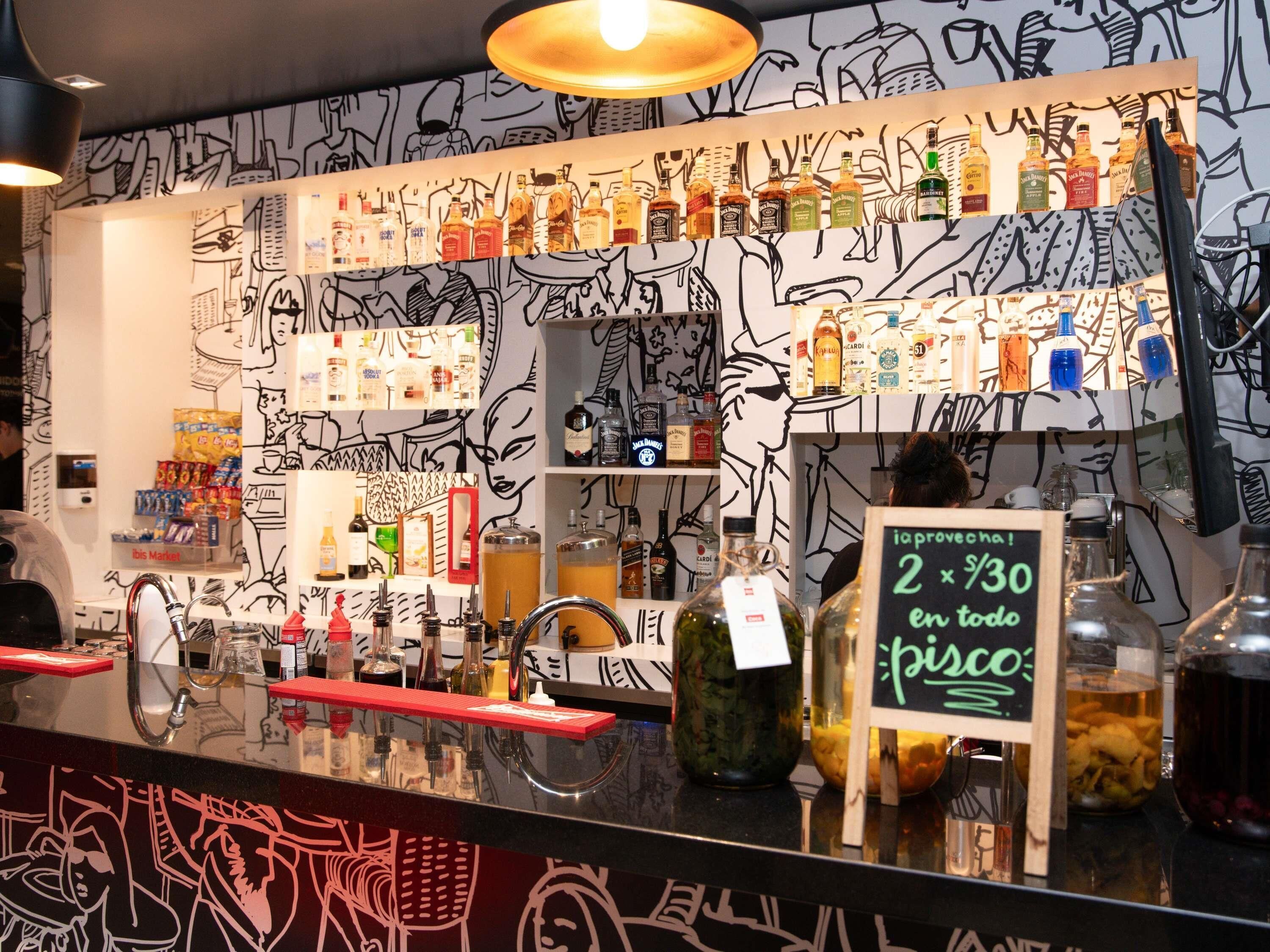 A bar area with a variety of liquor bottles and a sign offering a discount on pisco.
