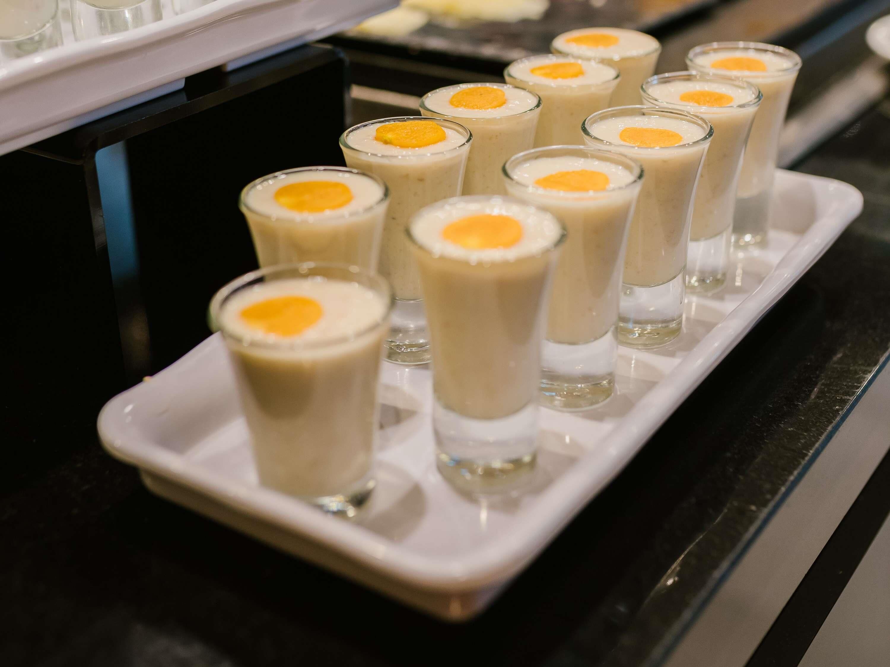 A tray of creamy beverages with a yellow garnish, likely served at a hotel or event.