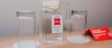 Tre contenitori di vetro con un'etichetta che riporta “AQUA FILTRADA ACQUA FILTRATA” e “ibis” su una superficie in legno.