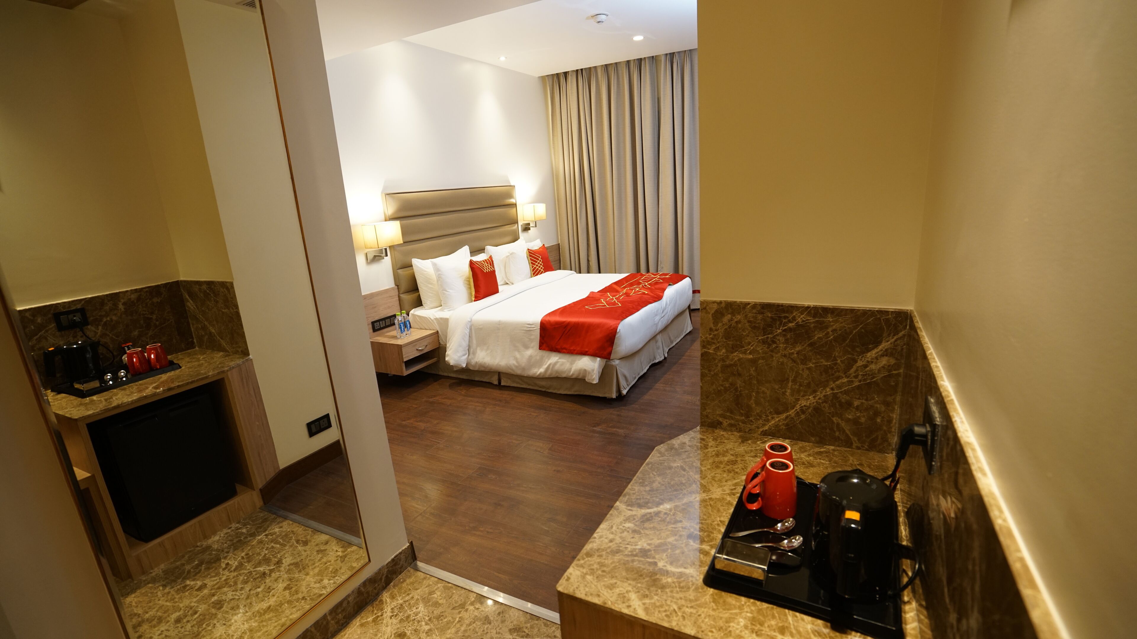 A hotel room with a bed, bedside table, and a coffee station.