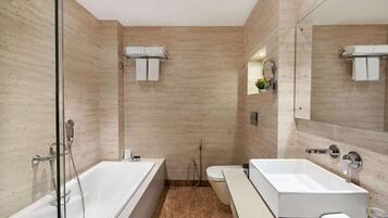 Un bagno moderno con doccia vetrata, una vasca da bagno bianca, un water e un mobile lavabo con specchio.