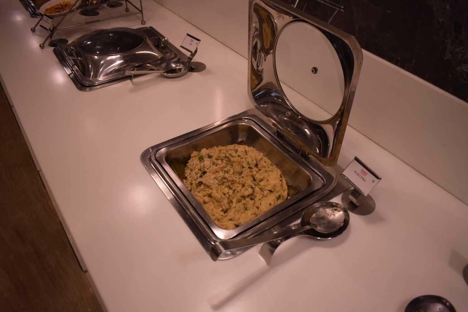 A buffet setup with a variety of dishes in metal serving trays.
