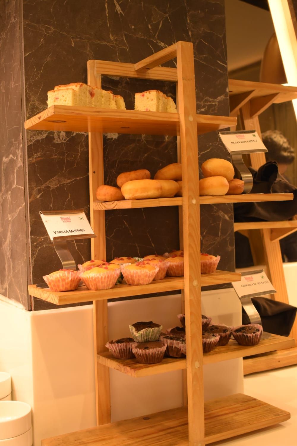 Une vitrine de boulangerie présentant diverses pâtisseries sur des étagères en bois.