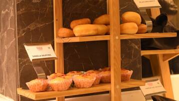 Une vitrine de boulangerie présentant diverses pâtisseries sur des étagères en bois.