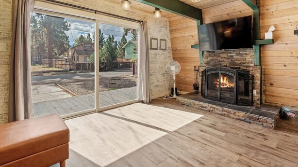 A cozy living room with a fireplace, large sliding glass doors, and a view of the outdoors.